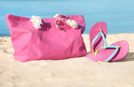 Stylish beach accessories on sand near the seaの写真素材