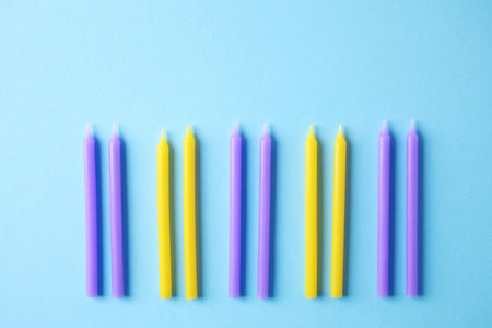 Colorful birthday candles on light blue background, flat layの写真素材