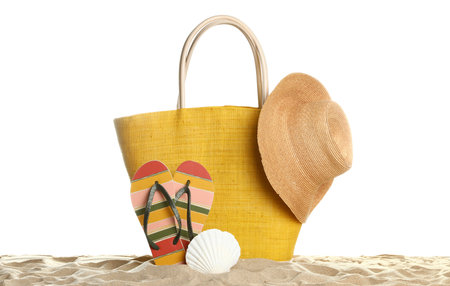 Stylish yellow bag and beach accessories on sand against white backgroundの写真素材
