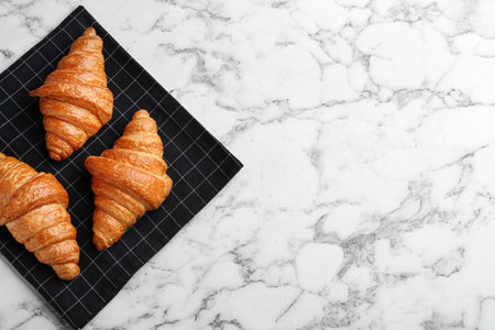 Fresh croissants on white marble table, flat lay with space for text. french pastryの写真素材