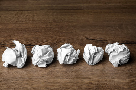 Balls of crumpled paper on wooden tableの写真素材