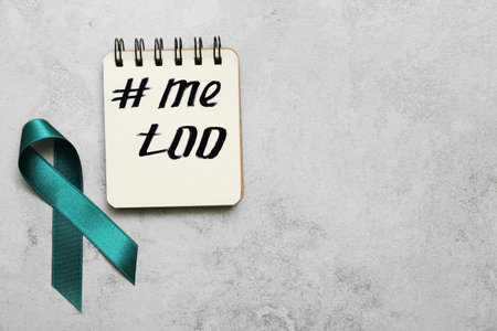 Teal awareness ribbon and notebook with hashtag METOO on gray background, flat lay. Stop sexual assaultの写真素材
