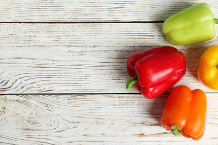 Ripe bell peppers on white wooden table, top view. Space for textの写真素材
