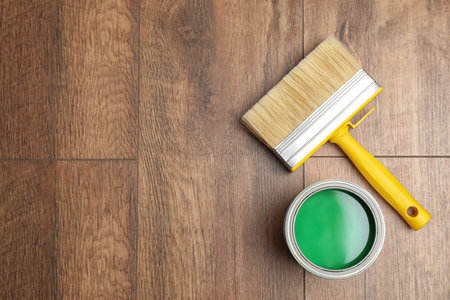 Can of green paint and brush on wooden background, flat lay. Space for textの写真素材