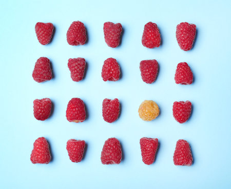 Flat lay composition with delicious ripe raspberries on blue backgroundの写真素材