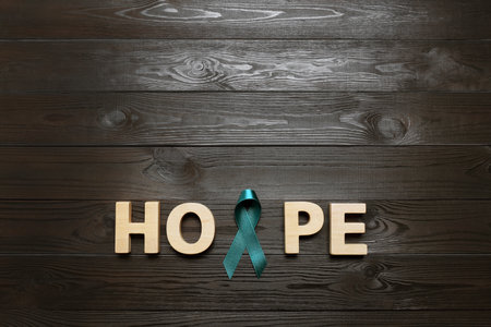 Word Hope made of letters and teal awareness ribbon on wooden background, top view. Symbol of social and medical issuesの写真素材