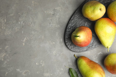 Ripe juicy pears on gray stone table, flat lay. Space for textの写真素材