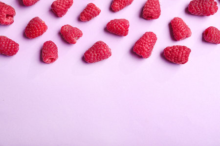 Tasty ripe juicy raspberries on pink background, top view with space for textの写真素材