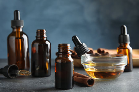 Composition with cinnamon essential oil on table against blue backgroundの写真素材