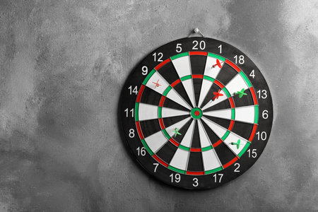 Arrows hitting dart board on gray wall. Space for textの写真素材