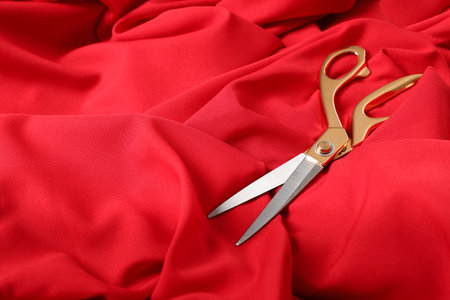 Sharp scissors on red fabric, space for text. Tailoring accessoriesの写真素材