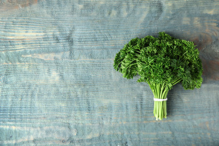 Bunch of fresh green parsley on blue wooden background, top view. Space for textの写真素材