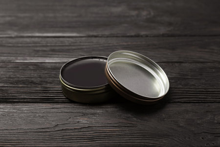 Can of black shoe polish on wooden table. Footwear care itemの写真素材
