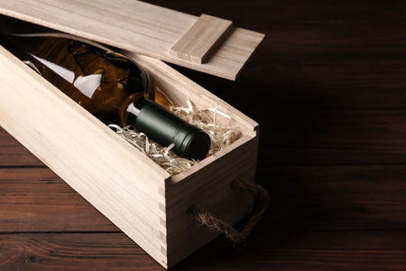 Open wooden crate with bottle of wine on tableの写真素材