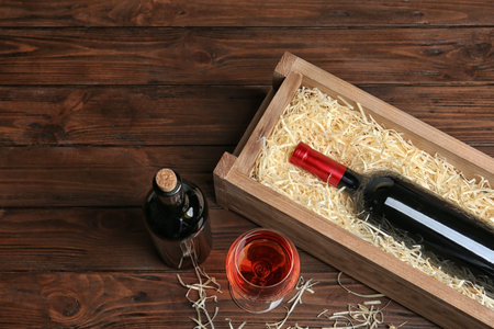 Composition with crate and bottles of wine on wooden tableの写真素材