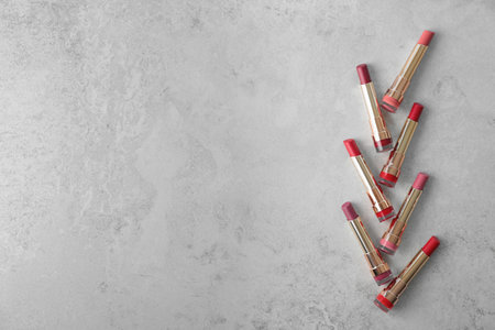 Set of bright lipsticks on gray background, flat lay. Space for textの写真素材