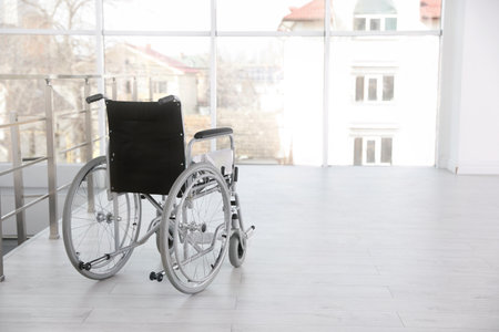 Modern wheelchair in empty room, space for text. Medical equipmentの写真素材