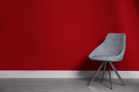 Gray modern chair for interior design on wooden floor at red wallの写真素材