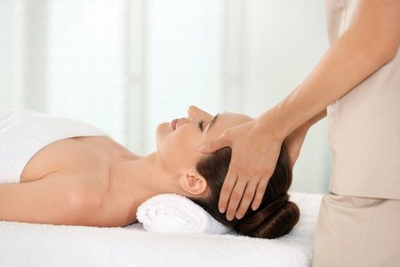 Beautiful young woman enjoying massage in spa salonの写真素材