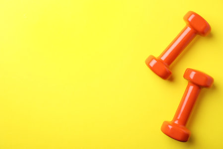 Bright dumbbells and space for text on color background, flat lay. home fitnessの写真素材
