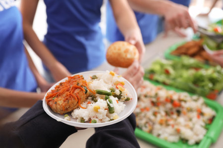 Volunteers serving food to poor people, closeupの写真素材