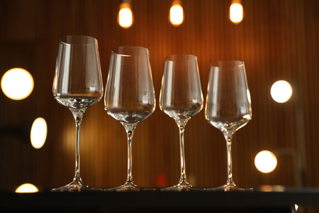 Empty wine glasses on table against blurred backgroundの写真素材
