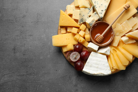 Different types of delicious cheese and snacks on served grey table, top view. Space for textの写真素材