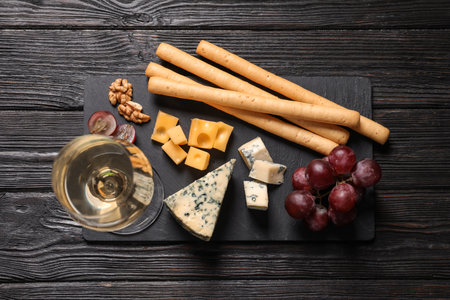 Flat lay composition with different types of delicious cheese on slate boardの写真素材