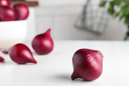 Fresh whole red onion bulb on white wooden table. Space for textの写真素材