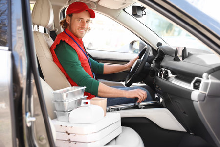 Male courier with orders in car. food delivery serviceの写真素材