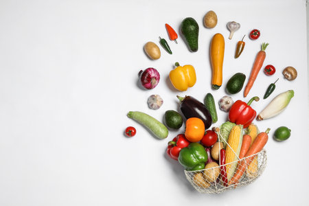Fresh vegetables and metal basket on white background, top viewの写真素材