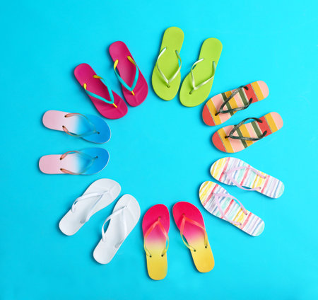 Flat lay composition with different flip flops on blue background, space for text. Summer beach accessoriesの写真素材