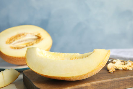 Wooden board with tasty cut ripe melon on tableの写真素材