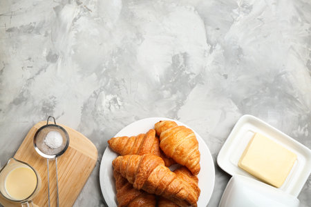 Plate of fresh croissants served on grey table, flat lay with space for text. French pastryの写真素材