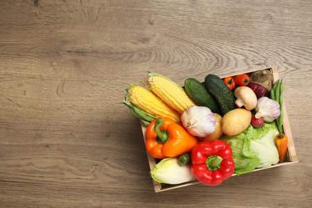 Crate with different fresh vegetables on wooden background, top view. Space for textの写真素材