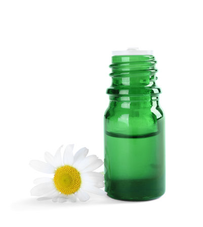 Bottle of herbal essential oil and chamomile flower isolated on whiteの写真素材