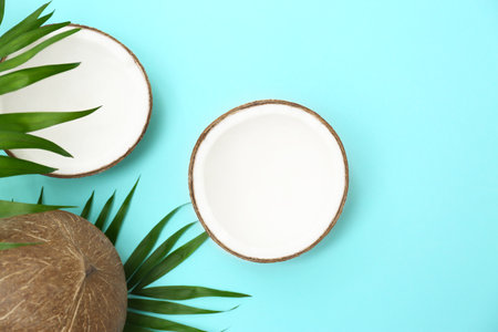 Fresh coconuts and palm leaves on light blue background, flat layの写真素材