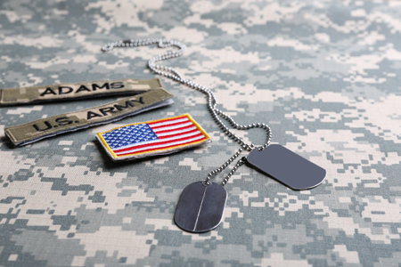 Military ID tags and US army patches on camouflage backgroundの写真素材