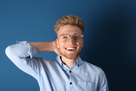 Portrait of handsome young man on blue backgroundの写真素材