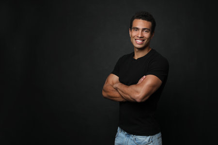 Handsome young African-American man on black background