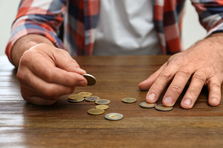 Senior man counting coins at table, closeupの写真素材