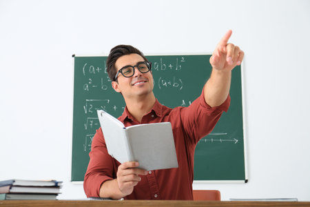 Young teacher working at table in classroomの写真素材