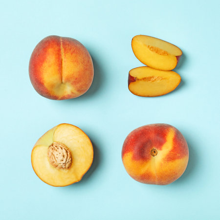 Sweet juicy peaches on light blue background, flat layの写真素材