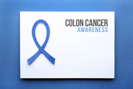 Card with words COLON CANCER AWARENESS and blue ribbon on color background, top view. Space for textの写真素材