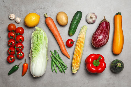 Flat lay composition of different fresh vegetables on gray tableの写真素材