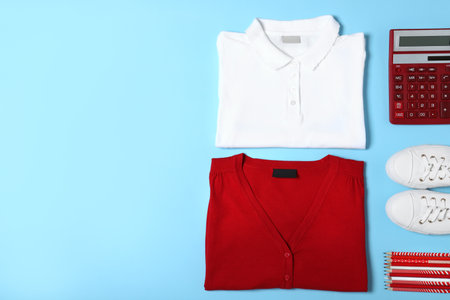 Flat lay composition with school uniform on blue background. Space for textの写真素材