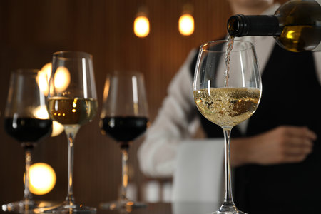 Waitress pouring wine into glass in restaurant, closeupの写真素材