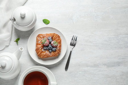 Fresh delicious puff pastry with sweet berries served on light table, flat lay. Space for textの写真素材