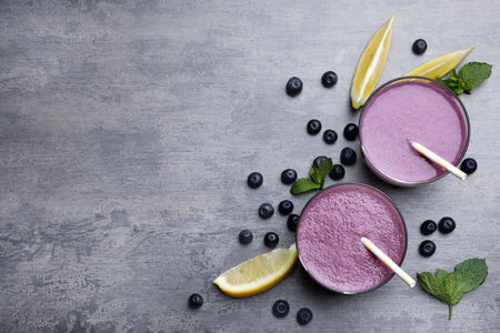 Flat lay composition with tasty acai drink, berries and space for text on gray tableの写真素材