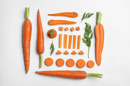 Tasty ripe carrots and leaves isolated on white, top view